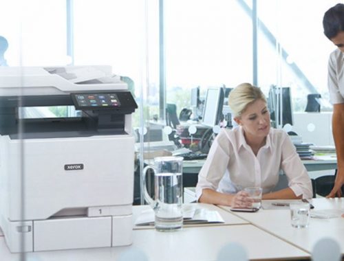 Dos mujeres trabajando en una oficina junto a una impresora multifunción en color Xerox® VersaLink® C625